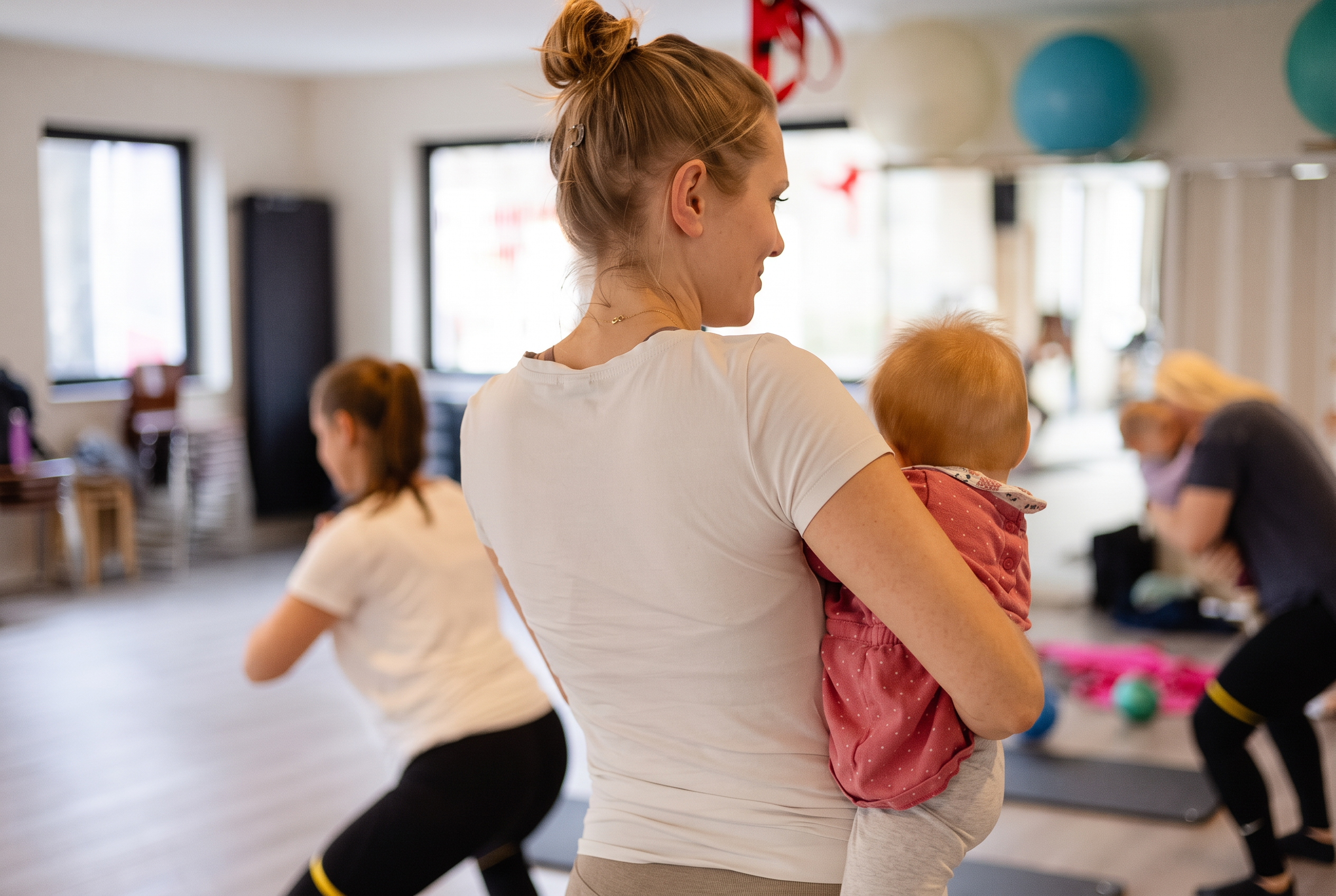 Mama mit Baby während des LOOMI-Trainings